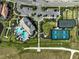 Aerial view of a community with a resort-style pool, tennis and pickleball courts, and lush landscaping at 6070 Mesa Gln, Bradenton, FL 34203