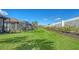 Spacious backyard view featuring lush landscaping, privacy wall, and a covered lanai at 6070 Mesa Gln, Bradenton, FL 34203