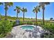 Relaxing outdoor hot tub area with lush landscaping and mature palms offering a tranquil retreat for residents at 6070 Mesa Gln, Bradenton, FL 34203