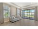 Bright living room with large windows, tray ceilings, and wood-look flooring at 6070 Mesa Gln, Bradenton, FL 34203