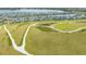 Aerial view of a large community recreation area with walking paths, landscaping, homes, and a lake at 6070 Mesa Gln, Bradenton, FL 34203