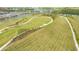 A grassy recreation area with walking paths and landscaping in the community with homes and a lake in the background at 6070 Mesa Gln, Bradenton, FL 34203