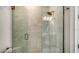 Modern tiled shower with glass door, rainfall shower head, and corner seat at 6070 Mesa Gln, Bradenton, FL 34203