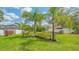 Spacious backyard with lush green grass, palm trees, and a white fence at 6433 Blue Grosbeak Cir, Lakewood Ranch, FL 34202