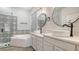 Elegant bathroom featuring dual vanities, patterned tile, a soaking tub, and a walk-in shower at 6433 Blue Grosbeak Cir, Lakewood Ranch, FL 34202