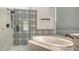 Sleek bathroom with tub and shower featuring black-and-white patterned tile at 6433 Blue Grosbeak Cir, Lakewood Ranch, FL 34202