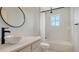 Modern bathroom with a vessel sink, black fixtures, and a tiled shower/tub combo with natural light at 6433 Blue Grosbeak Cir, Lakewood Ranch, FL 34202
