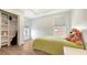Cozy bedroom with a plush green bed, natural light, and an organized closet with ample storage space at 6433 Blue Grosbeak Cir, Lakewood Ranch, FL 34202