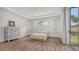 Bright bedroom with trey ceilings, wood floors, a vintage dresser and view to the back yard at 6433 Blue Grosbeak Cir, Lakewood Ranch, FL 34202