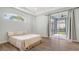 Bedroom with trey ceilings, wood floors, view to back patio, and a slider at 6433 Blue Grosbeak Cir, Lakewood Ranch, FL 34202