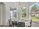 Dining area with large windows overlooking the backyard, modern lighting, and seating for six at 6433 Blue Grosbeak Cir, Lakewood Ranch, FL 34202