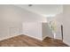 Bright hallway with wood-look floors, white walls, and an arched window providing natural light near staircase at 6433 Blue Grosbeak Cir, Lakewood Ranch, FL 34202