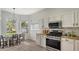 Bright kitchen with stainless steel appliances, eat in dining, and herringbone floors at 6433 Blue Grosbeak Cir, Lakewood Ranch, FL 34202
