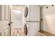 Bright laundry area features a stacked washer/dryer, built in bench, and stylish plank flooring at 6433 Blue Grosbeak Cir, Lakewood Ranch, FL 34202