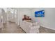 Bright living room featuring herringbone floors, a large arched window and a modern television at 6433 Blue Grosbeak Cir, Lakewood Ranch, FL 34202