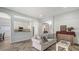 Bright living room with open floor plan to kitchen, dining area, and herringbone floors at 6433 Blue Grosbeak Cir, Lakewood Ranch, FL 34202