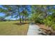 Paved community walking path surrounded by mature trees and lush green grass at 6433 Blue Grosbeak Cir, Lakewood Ranch, FL 34202