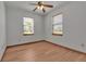 Simple bedroom with wood floors, ceiling fan, and two windows providing natural light at 6510 24Th E Ave, Bradenton, FL 34208