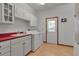 Laundry room with white cabinets, sink, red countertop, washer, dryer, and door to exterior at 6510 24Th E Ave, Bradenton, FL 34208