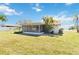Backyard view of the sunroom exterior with a beautiful lawn and mature landscaping at 6812 19Th W Ave, Bradenton, FL 34209
