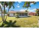 Lush green backyard with mature trees showcases the home's screened-in sunroom, perfect for outdoor enjoyment at 6812 19Th W Ave, Bradenton, FL 34209