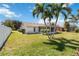 Lush backyard featuring mature palms and an inviting sunroom, adding charm to the property at 6812 19Th W Ave, Bradenton, FL 34209