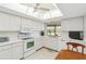 Efficient kitchen with white appliances, light countertops, and ample storage, designed for functionality and easy meal preparation at 6812 19Th W Ave, Bradenton, FL 34209