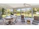 Bright sunroom featuring an oval dining table and chairs with views of the manicured backyard at 6812 19Th W Ave, Bradenton, FL 34209