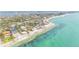 Stunning aerial view of beachfront homes along the clear, turquoise coastline with mature trees and nearby waterways at 7324 Point Of Rocks Rd, Sarasota, FL 34242