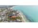 Picturesque aerial view of houses nestled near a turquoise shoreline, offering stunning waterfront living amidst lush greenery at 7324 Point Of Rocks Rd, Sarasota, FL 34242