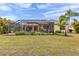 A view of the pool, backyard, and screened enclosure with lush landscaping and mature trees at 8224 Larkspur Cir, Sarasota, FL 34241