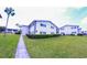 Condo building with green lawn, bushes, sidewalk and street parking at 105 47Th Avenue W Dr # 377, Bradenton, FL 34207