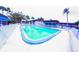 Inviting community pool surrounded by a white fence, palm trees and lounge seating area at 105 47Th Avenue W Dr # 377, Bradenton, FL 34207