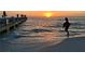 Beautiful sunset on the beach featuring people on a pier and gentle waves at 105 47Th Avenue W Dr # 377, Bradenton, FL 34207