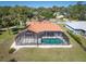 Aerial shot showcasing a private screened pool, neutral exterior paint, and a terra cotta colored roof at 108 Mccabe St, Port Charlotte, FL 33953