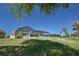 Exterior view of a lovely backyard with a screened in pool and lush green lawn at 108 Mccabe St, Port Charlotte, FL 33953