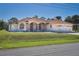 Beautiful single-story home with a red tile roof, arched windows, fountain and lush front lawn at 108 Mccabe St, Port Charlotte, FL 33953