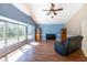 Bright living room featuring a large bay window, ceiling fan, and wood-look flooring at 108 Mccabe St, Port Charlotte, FL 33953