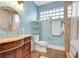 Elegant bathroom featuring a wooden vanity, a decorative mirror, and a modern toilet at 1135 Florida Ave, Sarasota, FL 34236