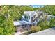 Back of house showing sunroom, and rooftop deck surrounded by lush trees at 1135 Florida Ave, Sarasota, FL 34236