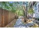 Side yard featuring a walkway, bamboo fence, mature trees, and easy backyard access at 1135 Florida Ave, Sarasota, FL 34236