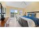 Bright bedroom features ensuite bath access, access to deck, and tile flooring at 1218 Spoonbill Landings Cir, Bradenton, FL 34209