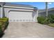 Attached two-car garage, showing concrete driveway and tidy landscaping at 1218 Spoonbill Landings Cir, Bradenton, FL 34209