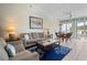 Inviting living room with comfortable sofa, stylish decor, ceiling fan, and access to the outdoor deck at 1218 Spoonbill Landings Cir, Bradenton, FL 34209
