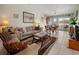 Inviting living room with neutral decor, tile floors, and sliding doors to a balcony with a waterfront view at 1218 Spoonbill Landings Cir, Bradenton, FL 34209