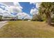 Expansive backyard with shed, scattered trees, and neighboring homes at 1269 Rasp Ct, North Port, FL 34288