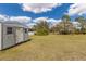 Large backyard featuring a metal shed, green grass, and some trees at 1269 Rasp Ct, North Port, FL 34288