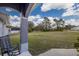 Covered porch overlooking the expansive backyard featuring a gray rocking chair and clear views at 1269 Rasp Ct, North Port, FL 34288