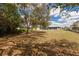 View of large backyard with lawn, mature trees, shed, and grey home exterior at 1269 Rasp Ct, North Port, FL 34288