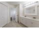 Bright bathroom with dual sinks, white cabinets, and an open doorway to the toilet at 1269 Rasp Ct, North Port, FL 34288